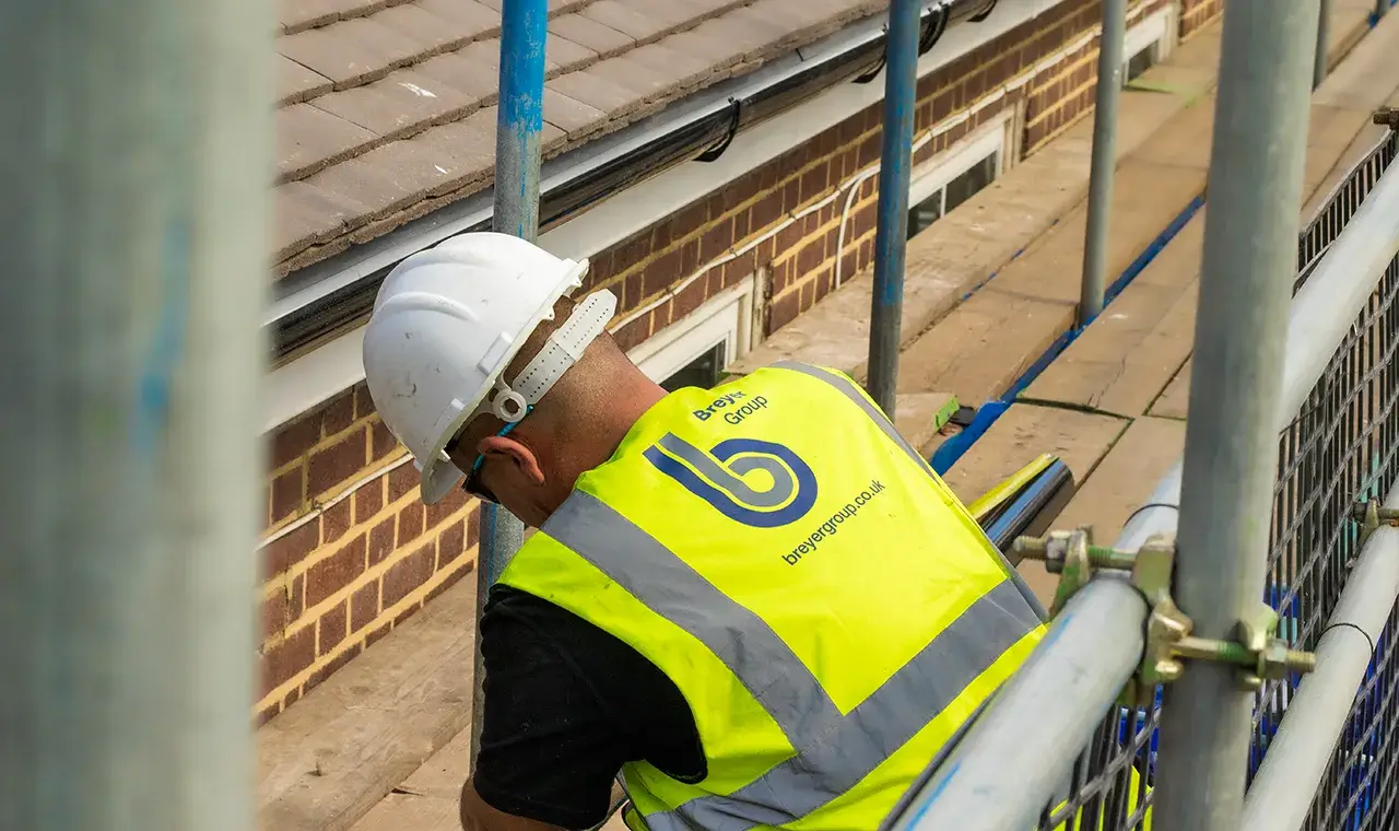 Breyer Operative working on roof on scaffolding with hi-vis